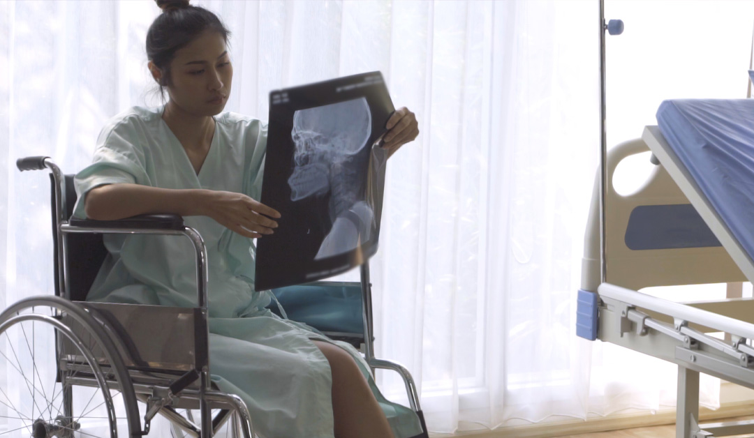 Patient On Wheel Chair With X-ray In Hand